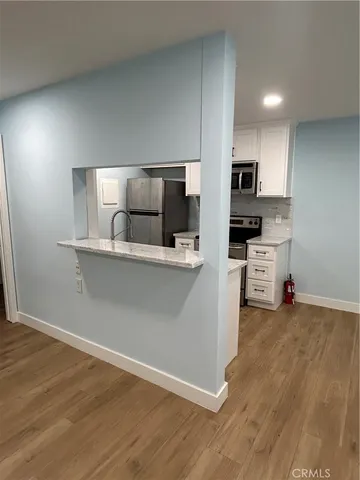 a kitchen with stainless steel appliances a refrigerator and a stove top oven