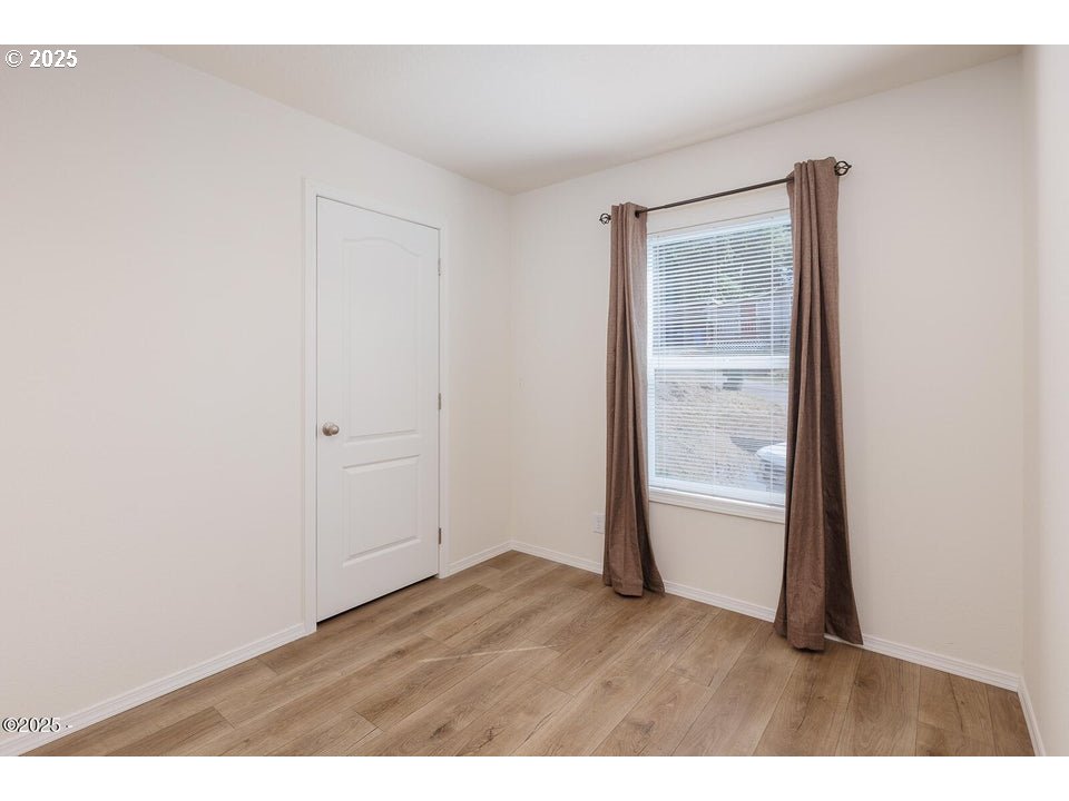 150 Northwest 5th Street Toledo, OR 97391 - Photo 14 of 26 an empty room with wooden floor and windows