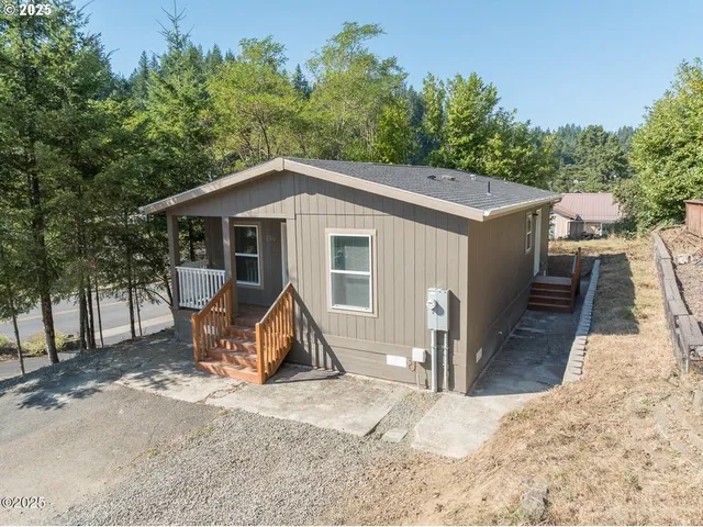 a view of a house with a yard and large trees