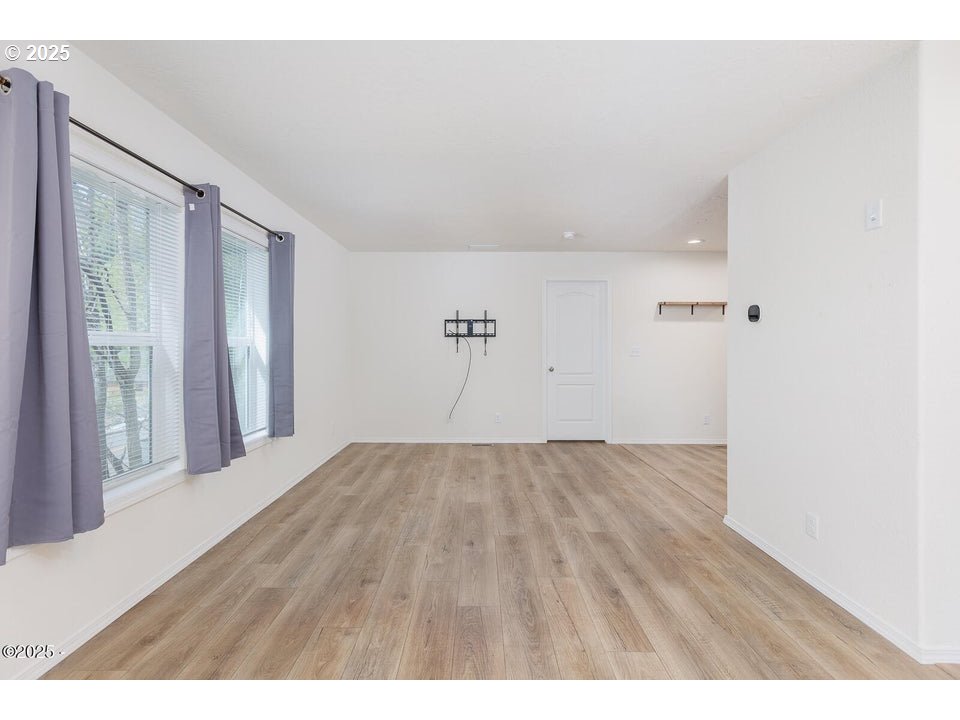 150 Northwest 5th Street Toledo, OR 97391 - Photo 3 of 26 a view of an empty room with wooden floor