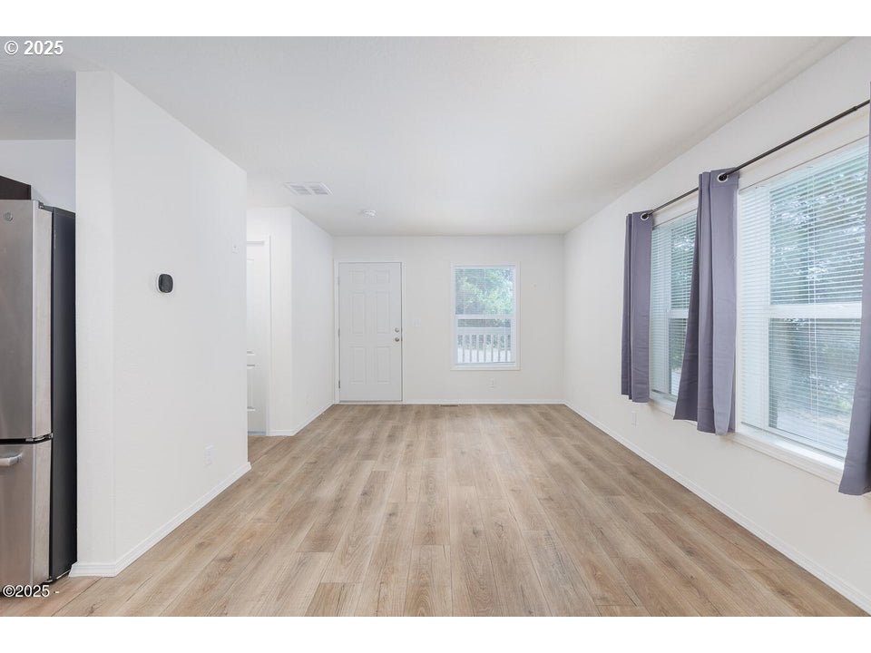 150 Northwest 5th Street Toledo, OR 97391 - Photo 4 of 26 a view of an empty room with wooden floor and a window