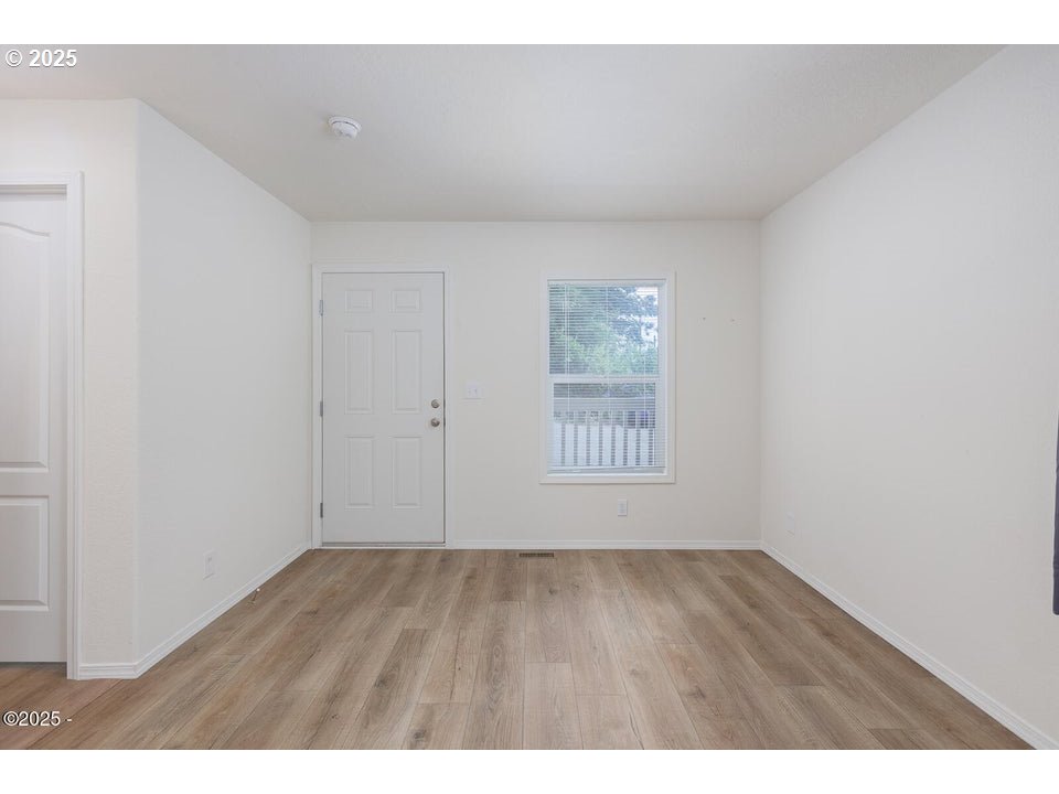 150 Northwest 5th Street Toledo, OR 97391 - Photo 5 of 26 a view of an empty room with wooden floor and a window