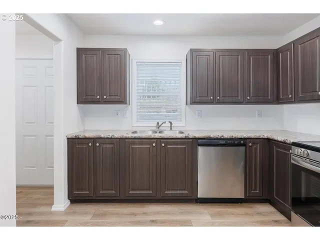 a kitchen with granite countertop a refrigerator stove and cabinets