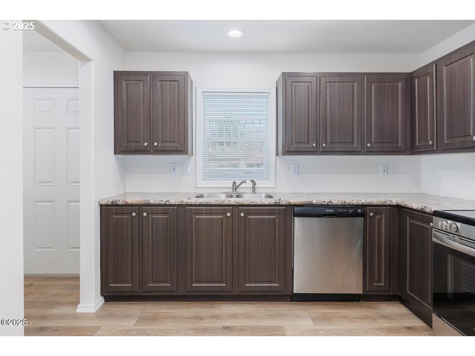 150 Northwest 5th Street Toledo, OR 97391 - Photo 10 of 26 a kitchen with granite countertop a refrigerator stove and cabinets