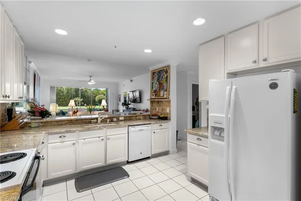 a kitchen with white cabinets and white appliances