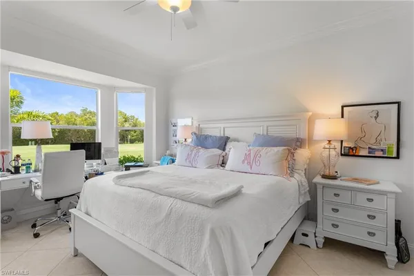 a bedroom with a bed and large window