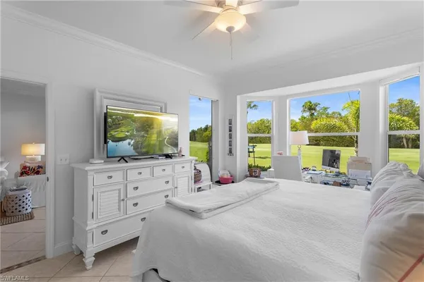a bedroom with a bed flat screen tv and a large window