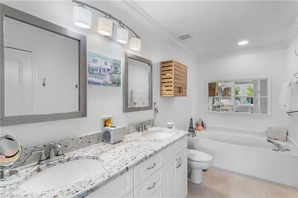 a bathroom with a granite countertop sink mirror vanity and toilet