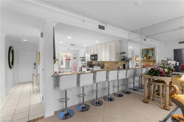 a large white kitchen with lots of counter space and windows