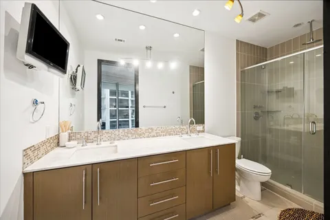 a bathroom with a granite countertop sink toilet a large mirror and shower