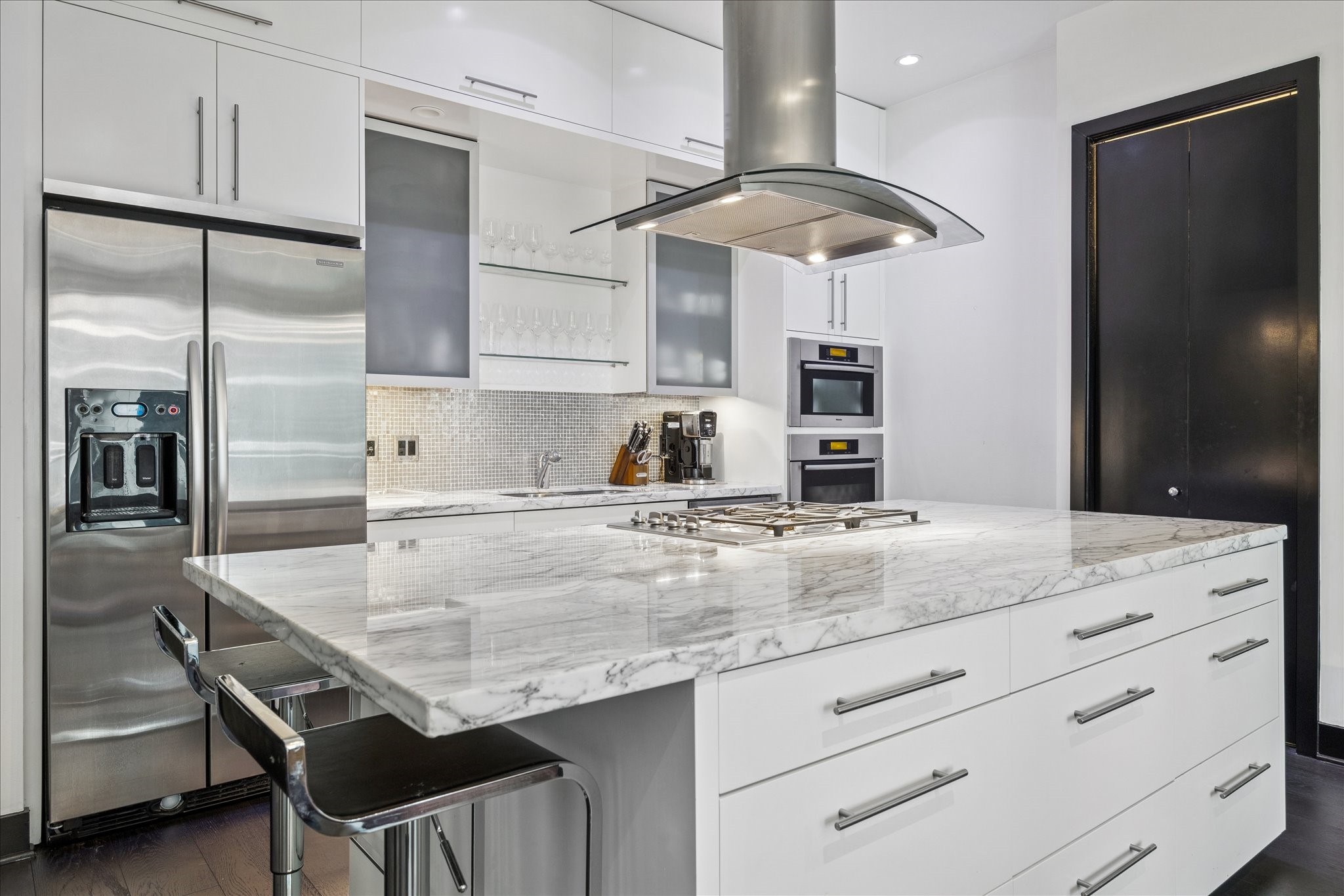 1600 Post Oak Boulevard, Unit 1007 Houston, TX 77056 - Photo 4 of 14 a kitchen with a table chairs stainless steel appliances and cabinets