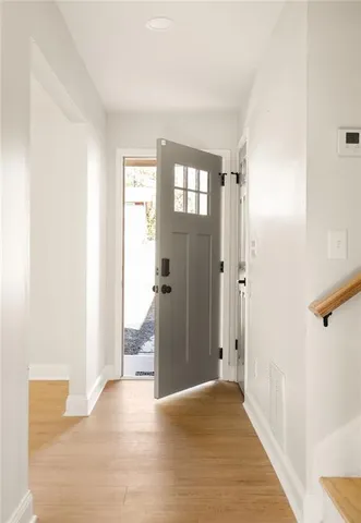 a view of a hallway with wooden floor and a living room