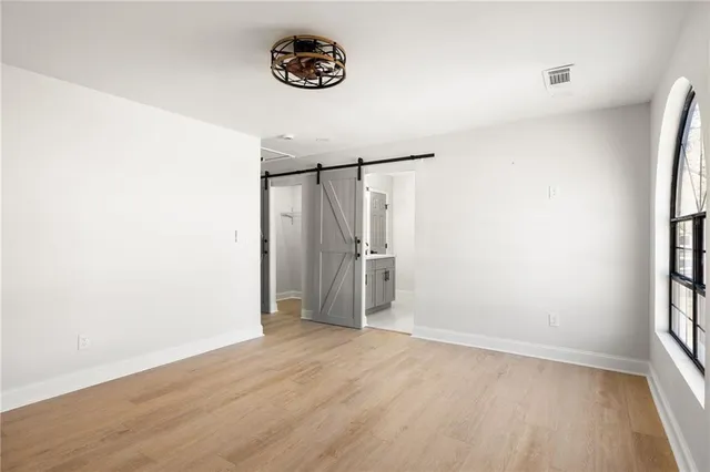 an empty room with wooden floor and window