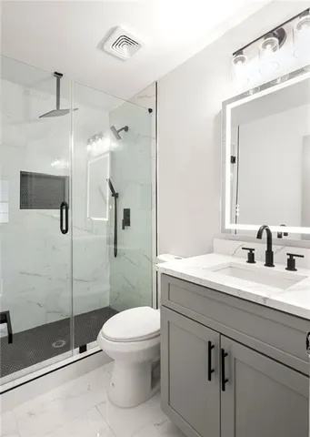 a bathroom with a sink a toilet and shower