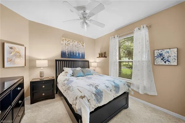 a bedroom with a bed a dresser next to a window