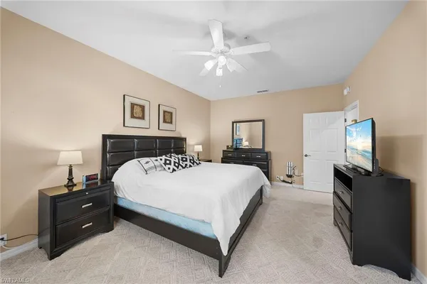 a spacious bedroom with a bed and a flat screen tv