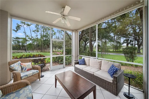 a living room with patio furniture and a floor to ceiling window