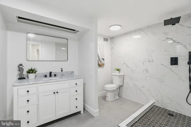 a spacious bathroom with a toilet sink and a mirror