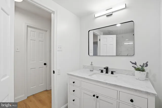 a bathroom with a sink vanity granite and a mirror
