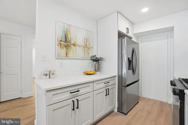 a kitchen with stainless steel appliances a refrigerator a sink and cabinets
