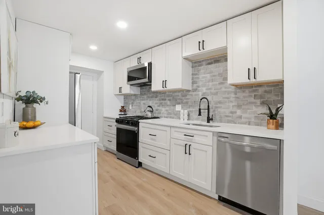 a kitchen with a sink a stove and cabinets