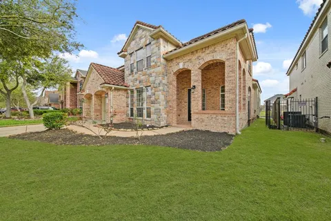 a view of a big house with a big yard and large tree