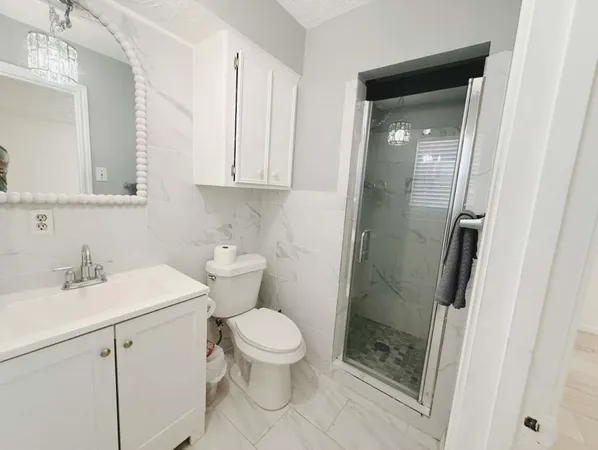 a bathroom with a sink a toilet and shower