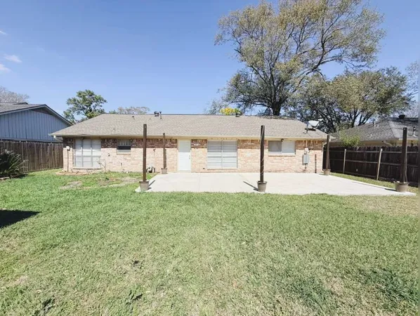a view of a house with backyard and a tree