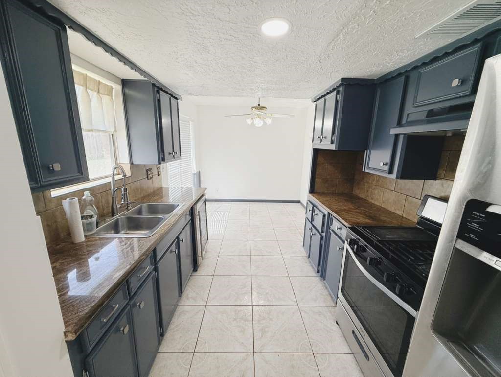 9231 Friendship Road Houston, TX 77080 - Photo 4 of 12 a kitchen with stainless steel appliances granite countertop a sink stove and refrigerator