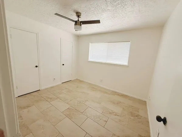 a view of a room with a ceiling fan and a window