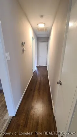 a view of a hallway with wooden floor