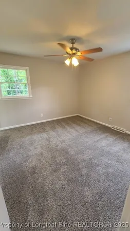 an empty room with a window and a fan