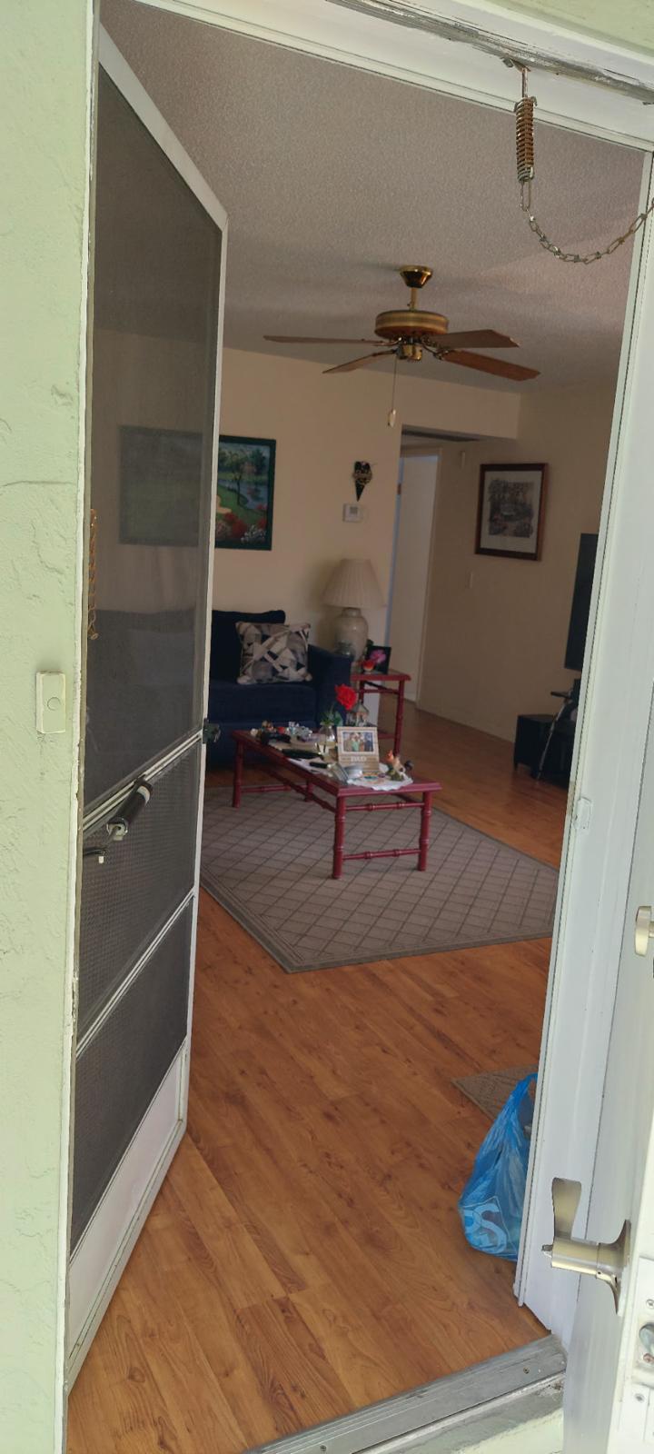 3100 Springdale Boulevard, Unit 317 Palm Springs, FL 33461 - Photo 3 of 18 a living room with hard wood floors and a ceiling fan