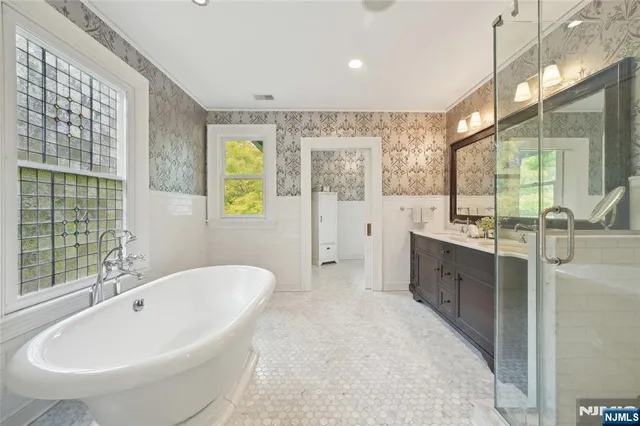 a spacious bathroom with a tub sink and mirror