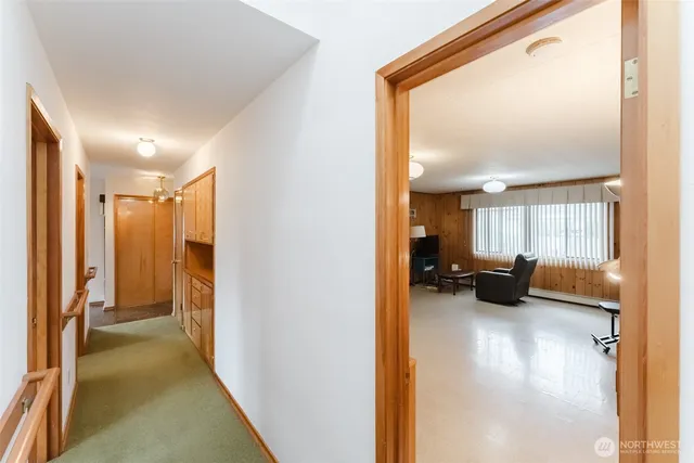 a view of a hallway with couch and a view of living room
