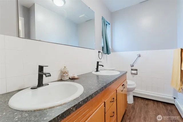 a bathroom with a granite countertop sink a toilet and a mirror