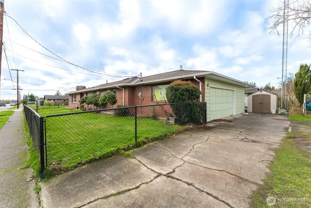 a view of a house with backyard and trees in the background