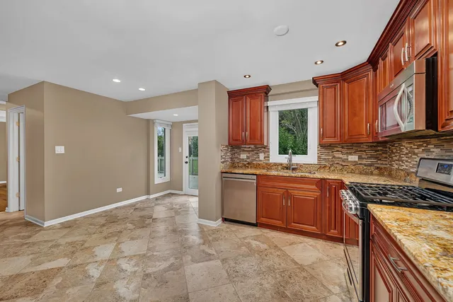 a kitchen with stainless steel appliances granite countertop a stove sink and cabinets