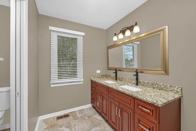 a bathroom with a granite countertop sink and a mirror