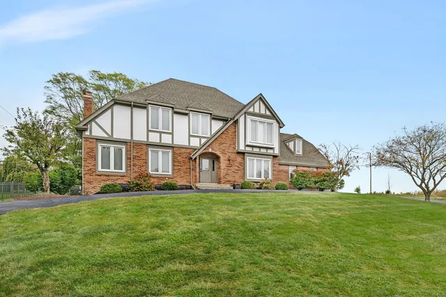 a view of a house with a big yard and large trees