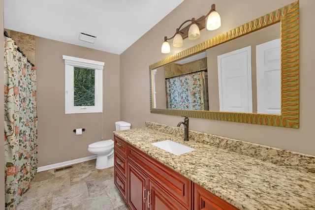 a bathroom with a granite countertop sink and a mirror