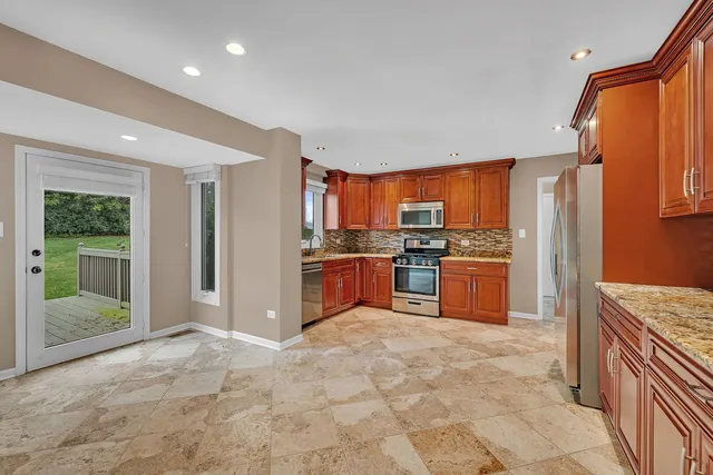 a kitchen with stainless steel appliances granite countertop a refrigerator and a sink