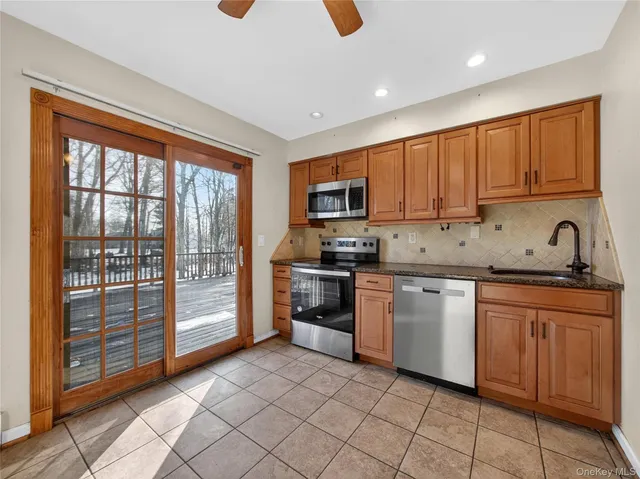 a kitchen with granite countertop a stove top oven sink and cabinets