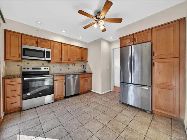 a kitchen with stainless steel appliances granite countertop a refrigerator sink and stove