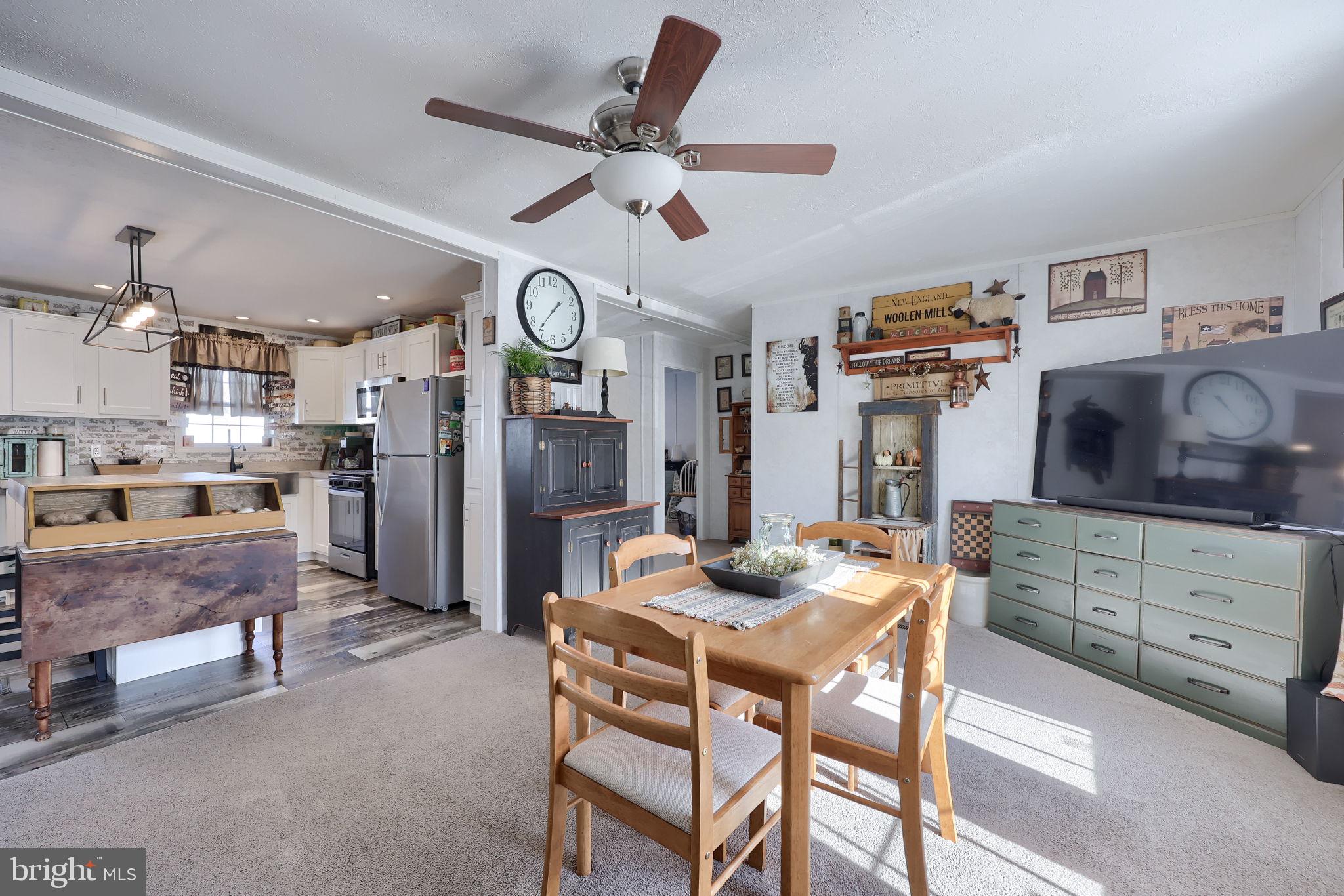 1395 Bowmansville Road Mohnton, PA 19540 - Photo 11 of 26 a kitchen with stainless steel appliances kitchen island granite countertop a table chairs and a refrigerator
