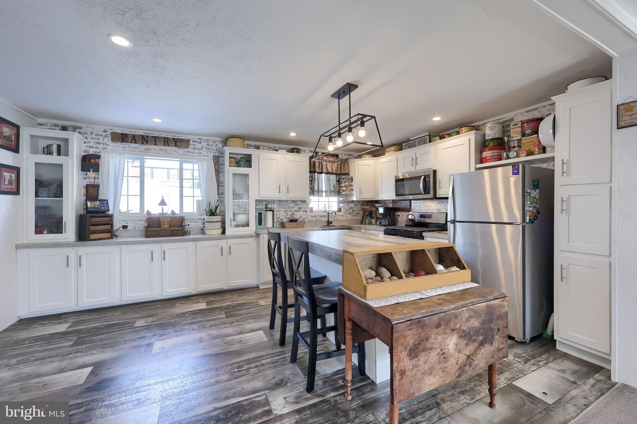 1395 Bowmansville Road Mohnton, PA 19540 - Photo 15 of 26 a kitchen with stainless steel appliances granite countertop a refrigerator a sink dishwasher a stove and white cabinets with wooden floor