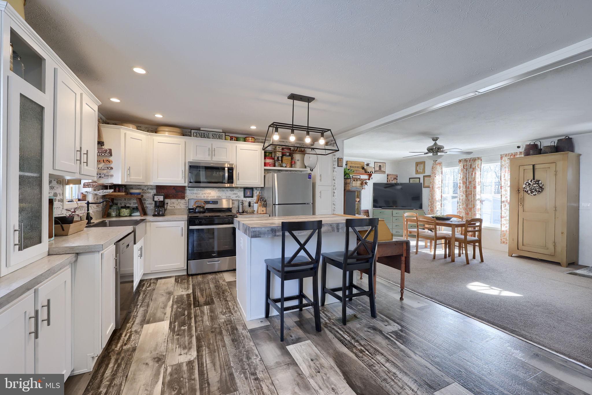 1395 Bowmansville Road Mohnton, PA 19540 - Photo 18 of 26 a kitchen with a dining table chairs appliances and cabinets