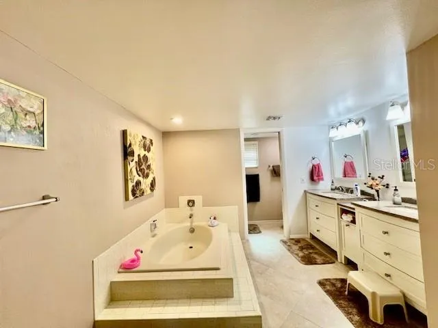 a spacious bathroom with a tub sink and mirror