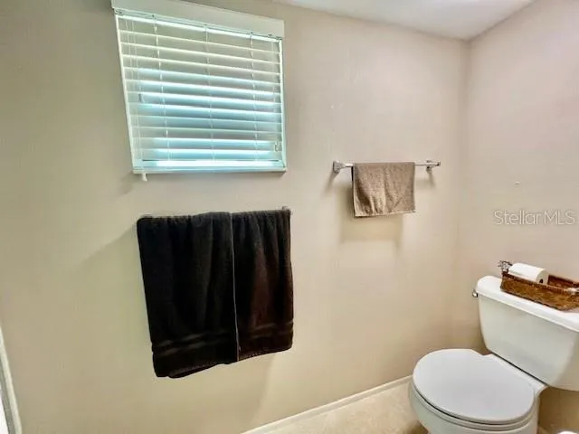 a bathroom with a toilet and a window