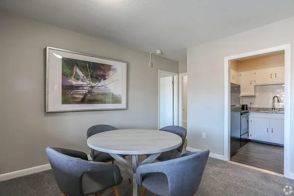 a view of a dining room with furniture a rug and wooden floor